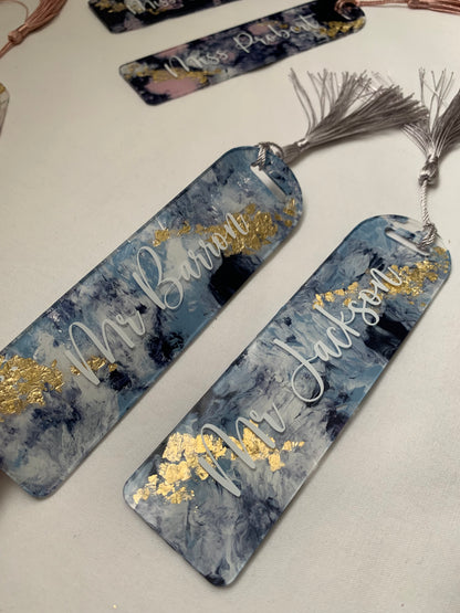 Hand painted bookmarks with gold foil and a silver tassel, featuring white font on a blue and gold background.